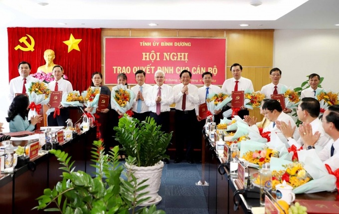 Bí thư Tỉnh ủy Nguyễn Văn Lợi (giữa), Phó Bí thư Thường trực Tỉnh ủy Nguyễn Hoàng Thao (thứ 5 từ phải qua), Chủ tịch UBND tỉnh Võ Văn Minh (thứ 5 từ trái qua) trao quyết định và tặng hoa cho các đồng chí được điều động, bổ nhiệm, bổ nhiệm lại.