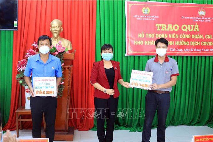 Lãnh đạo tỉnh Vĩnh Long trao quà tượng trưng cho các Công đoàn cơ sở có công nhân lao động bị ảnh hưởng dịch COVID-19. Ảnh: TTXVN