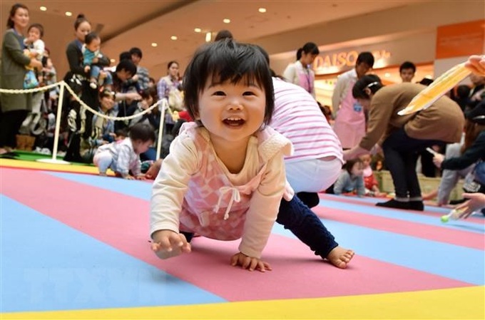 Em bé tham gia cuộc thi bò tại Yokohama, tỉnh Kanagawa, Nhật Bản. (Ảnh: AFP/ TTXVN)