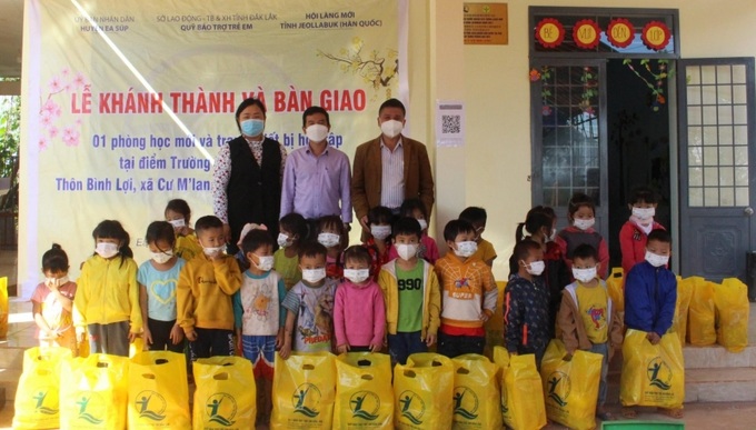 Lãnh đạo Quỹ Bảo trợ trẻ em tỉnh Đắk Lắk và chính quyền địa phương tặng quà Tết cho các em học sinh. Ảnh: baodaklak.vn