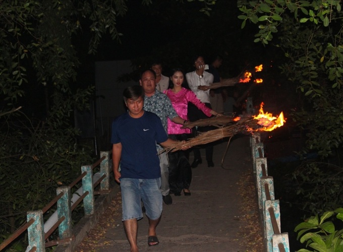 Du khách được trải nghiệm cầm đuốc lá dừa đi cả cây số trong đêm đến đình thần ở cù lao An Bình xem hát bội.