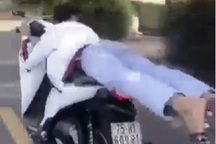 Nam thanh niên nằm trên yên lái xe máy lạng lách, đánh võng