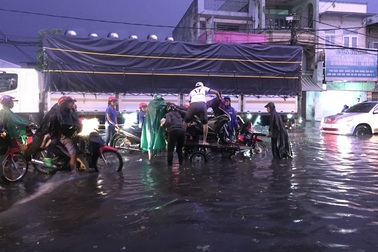 Người dân Biên Hòa bì bõm lội nước sau cơn mưa lớn đầu mùa