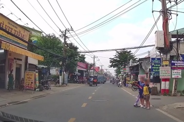 Vội vượt ô tô, người đi xe máy lao vào hai em nhỏ đang đi bộ sang đường