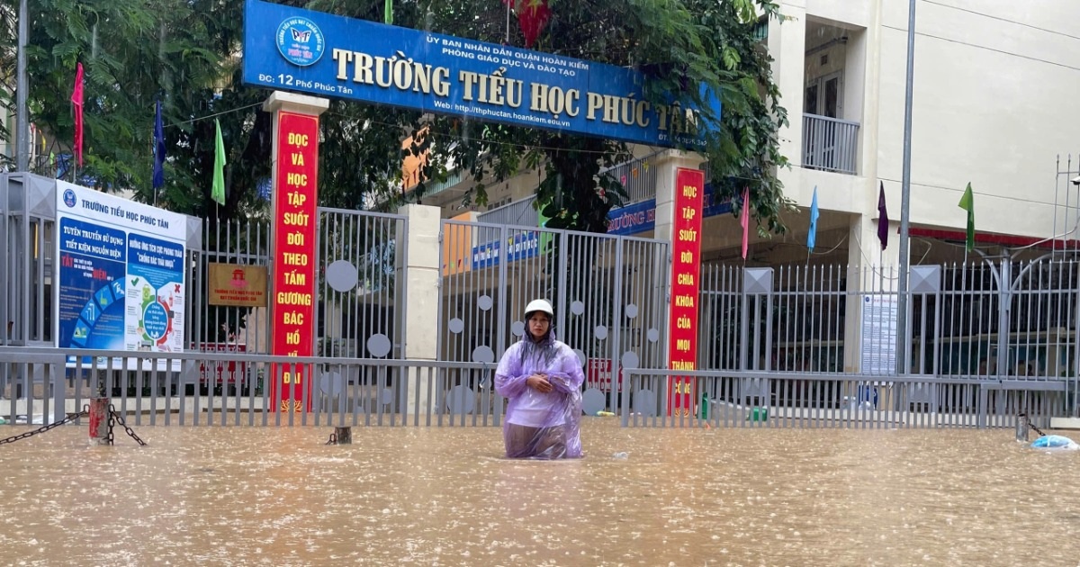 Cán bộ, giáo viên Trường Mầm non Tuổi Hoa đang tích cực thu dọn, di chuyển đồ đạc lên tầng trên (Ảnh: Mỹ Hà).