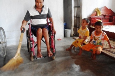 Bố ngồi xe lăn bất lực nhìn con thơ tật nguyền