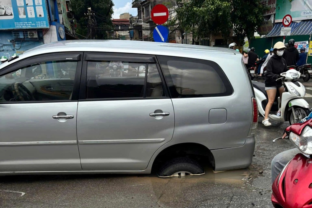 Hà Nội: Ô tô đang đi trên đường bất ngờ bị tụt bánh xuống hố - 1 Hà Nội: Ô tô đang đi trên đường bất ngờ bị tụt bánh xuống hố - 1