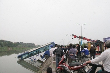 Tránh cụ già qua đường, xe khách lao xuống sông