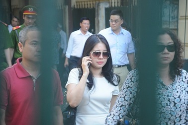 Người vợ xinh đẹp của “bầu” Kiên đứng đợi cửa tòa vẫy tay chào chồng 