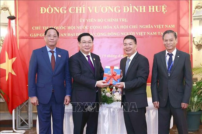 Chủ tịch Quốc hội Vương Đình Huệ trao tập sách tượng trưng (tủ sách về Bác Hồ) cho Đại sứ và đại diện cộng đồng - Ảnh: TTXVN

