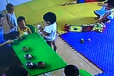 Cô nuôi véo vào tai trẻ trong lúc cho ăn