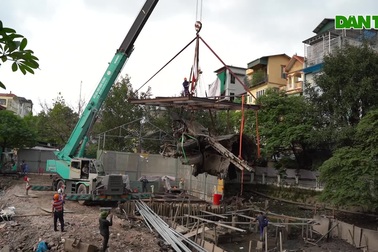 Cần cẩu nhấc bổng mảnh xác pháo đài bay B-52 dưới đáy hồ lên bờ ở Hà Nội