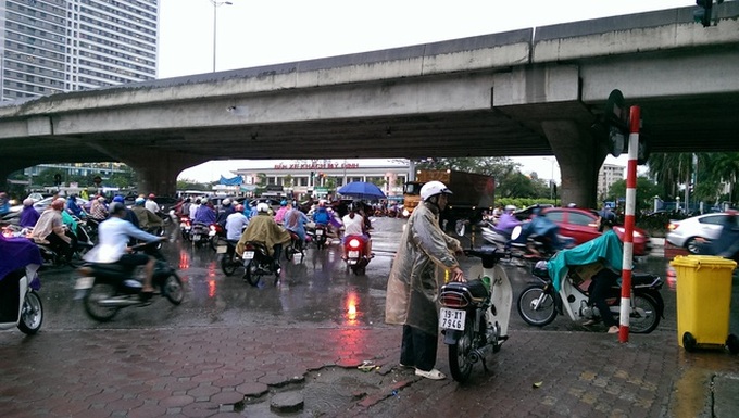 Trời mưa to nhưng ông Định vẫn đứng chờ khách. (Ảnh chụp chiều 6/6).