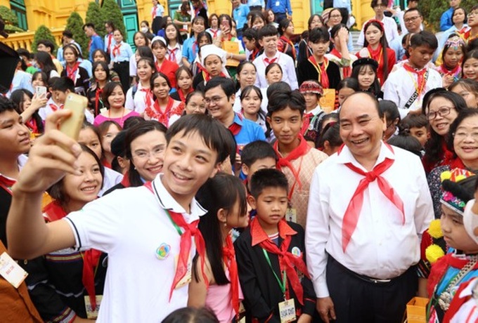 Chủ tịch nước Nguyễn Xuân Phúc chụp ảnh lưu niệm với thiếu nhi. Ảnh: VIẾT CHUNG.
