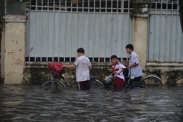 Học sinh bì bõm lội nước về nhà sau cơn mưa chiều