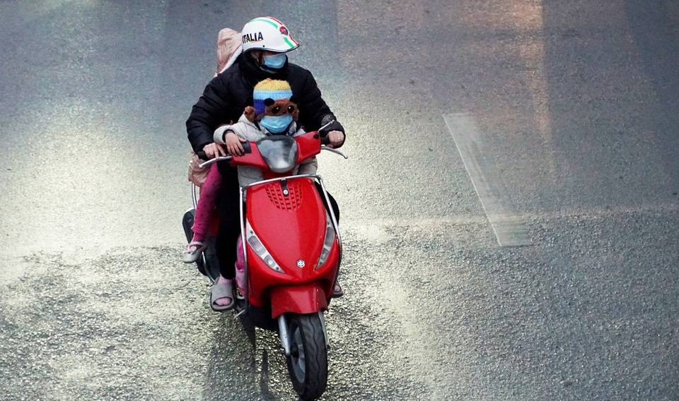 Trẻ em được bố mẹ bọc kín mít đi đường trong tiết trời lạnh giá ở Hà Nội - 3