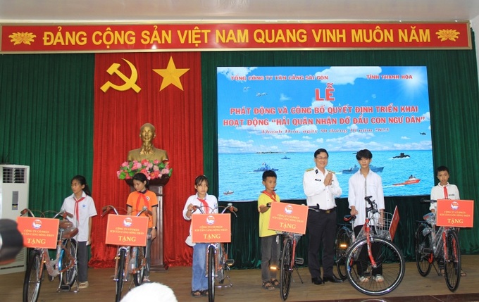 Đại diện Tổng Công ty Tân Cảng Sài Gòn và lãnh đạo tỉnh Thanh Hóa trao tặng Quyết định nhận đỡ đầu và xe đạp cho các em học sinh tại buổi lễ