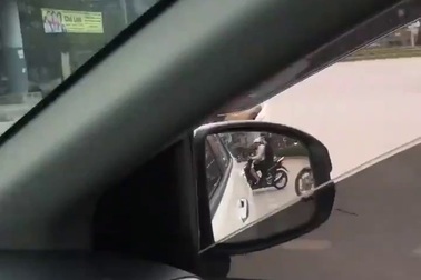 Người phụ nữ đi xe máy thản nhiên dựng xe giữa đường nói chuyện điện thoại