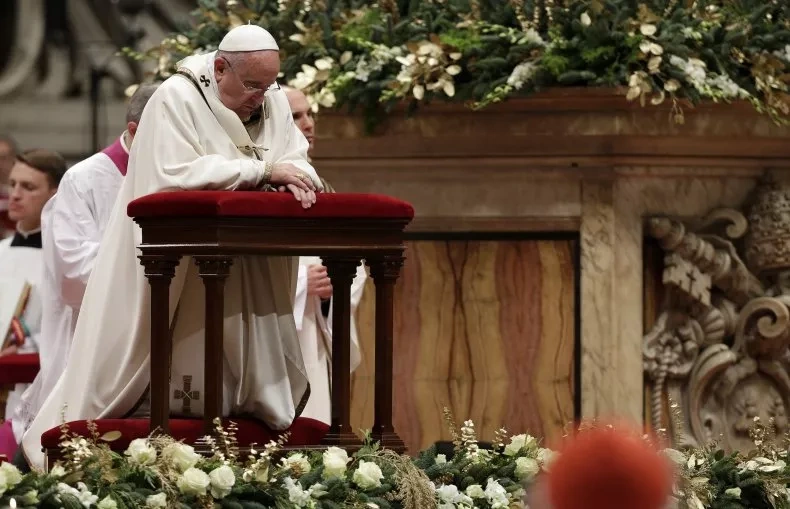 Giáo hoàng quỳ gối khi chủ trì thánh lễ đêm Giáng sinh tại Vương cung thánh đường St. Peter ở Vatican vào ngày 24/12/2014 (Ảnh: Reuters).