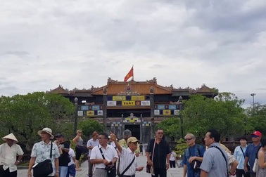 1 "HDV" không đeo thẻ hướng dẫn đoàn khách Nhật tại Đại Nội, sau khi thấy PV bèn dẫn đoàn nhanh qua nơi khác