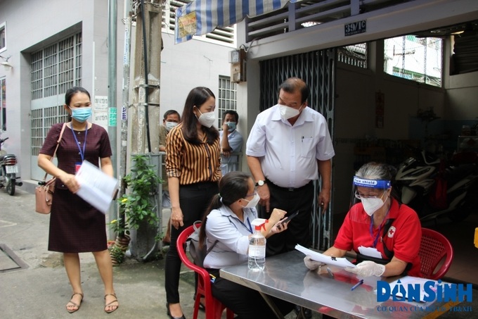Ông Lê Minh Tấn, Giám đốc Sở LĐ-TB&XH TP.HCM hướng dẫn cán bộ Phường 17 cách tra cứu và cập nhật thông tin lên mềm ứng dụng quản lý chi trả hỗ trợ.