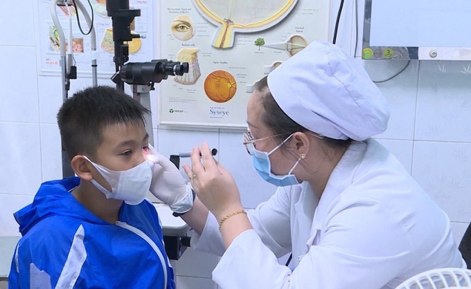 Bác sĩ khám đau mắt đỏ cho trẻ em.