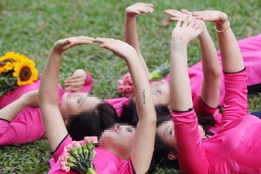 Bất chấp biển cấm, nữ sinh vẫn ngồi lên cỏ chụp kỷ yếu