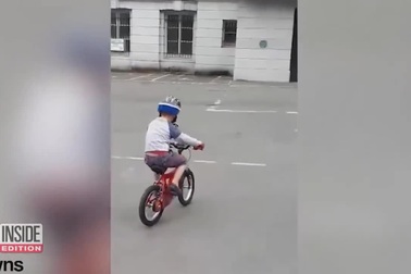 "Bóng ma" tựa cửa sổ nhìn cậu bé con đi xe đạp gây sốt mạng