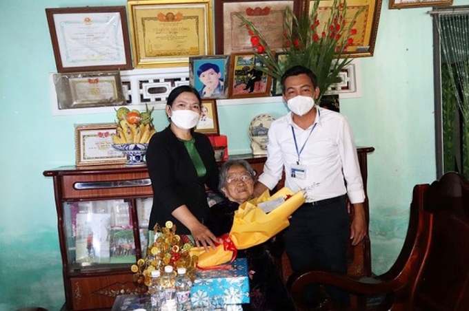 Đồng chí Phan Công Trinh, Phó Chủ tịch UBND huyện và cô Trần Thị Lệ Thủy, Hiệu trưởng Trường THPT Lê Hồng Phong tặng quà Mẹ Nguyễn Thị Cận.