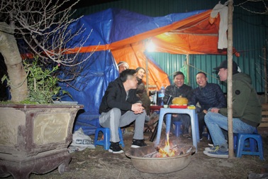 Người Hà Nội đốt củi sưởi ấm, thức trắng đêm trông đào giữa giá rét