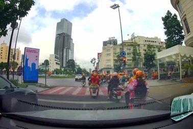 Nhóm người đi xe máy thản nhiên nối đuôi nhau vượt đèn đỏ