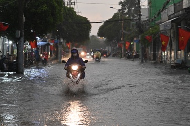 Người dân TPHCM chật vật trong cơn mưa giờ tan tầm
