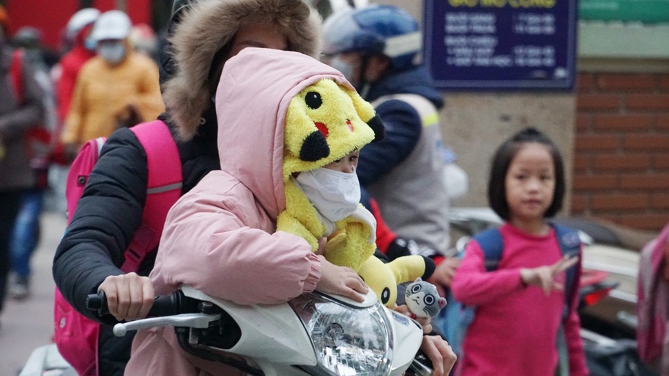 Trẻ em được bố mẹ bọc kín mít đi đường trong tiết trời lạnh giá ở Hà Nội - 9