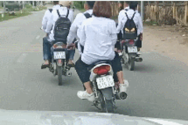 Nhóm học sinh đi xe máy không đội mũ bảo hiểm còn dàn hàng ngang cản trở giao thông