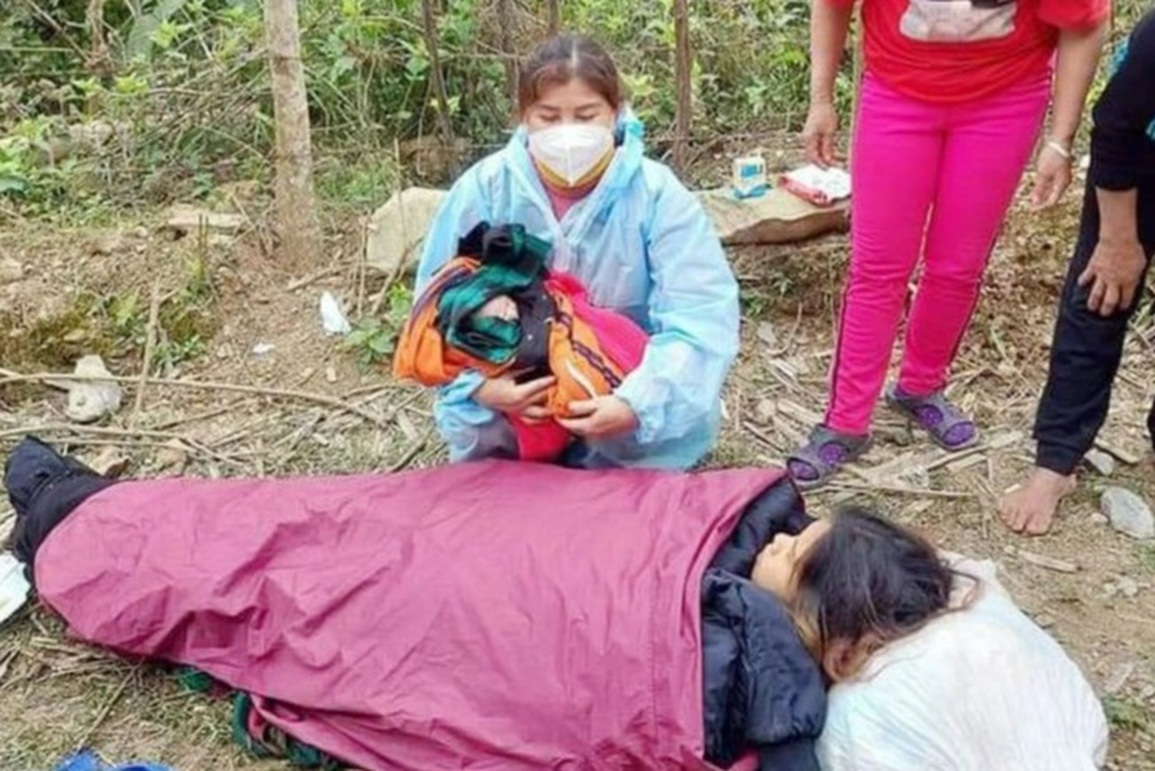 Cán bộ trạm y tế dùng áo mưa hỗ trợ sản phụ sinh con bên đường - 1