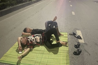 Hai nhân viên quán ốc nằm trên quốc lộ chụp ảnh "câu like"