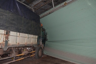 Xe tải cuốn theo người đi xe máy, lao vào xưởng cơ khí