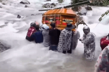 Cả chục người khiêng quan tài vượt dòng nước lũ chảy cuồn cuộn