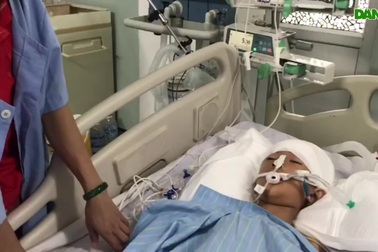 Con nằm trên giường bệnh, người mẹ nghèo ngậm ngùi nhìn con.