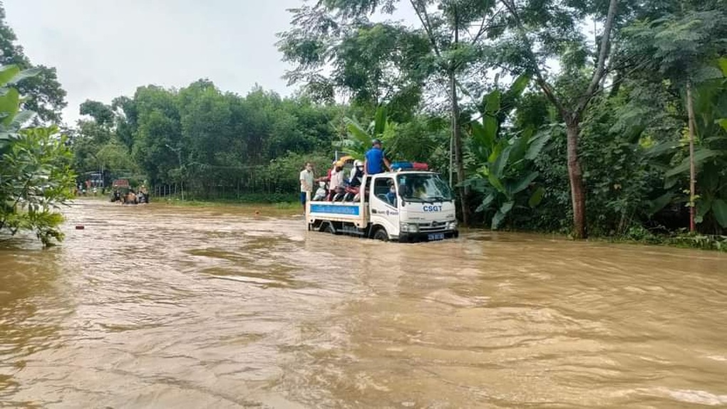 CSGT hóa lái đò chở người dân đi qua điểm úng ngập trên quốc lộ 2 - 2 CSGT hóa lái đò chở người dân đi qua điểm úng ngập trên quốc lộ 2 - 2