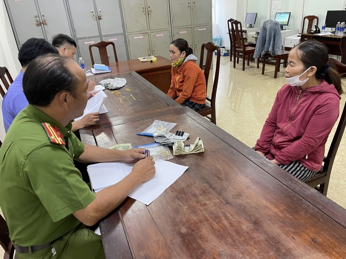 Lê Thị Trơi (áo đỏ sẫm) và Lê Thị Phương Mai (áo màu cam) cùng tang vật vụ án tại cơ quan Công an