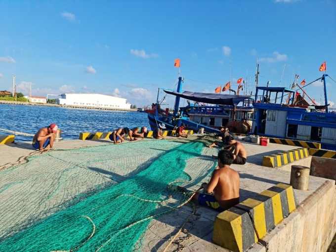 Ngư dân vá lưới trên âu tàu đảo Trường Sa lớn, thị trấn Trường Sa.