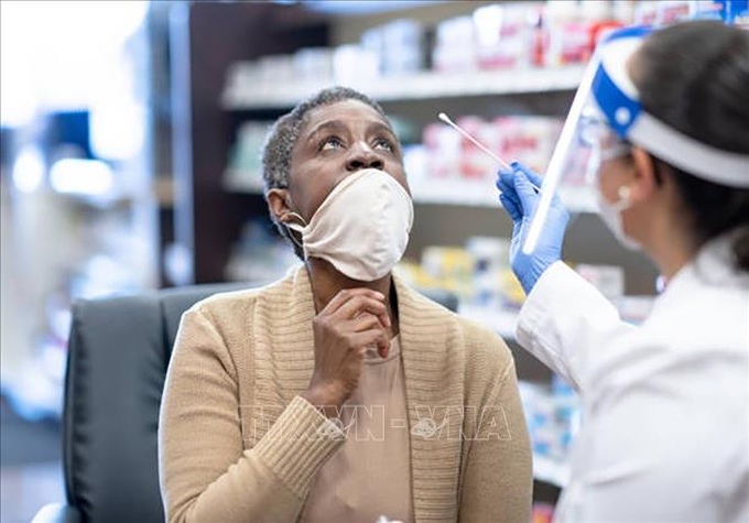 Nhân viên y tế lấy mẫu xét nghiệm COVID-19 cho người dân tại Toronto, tỉnh Ontario, Canada. Ảnh: GETTY IMAGES/TTXVN