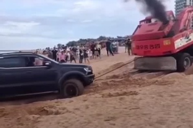 Chạy trên bãi biển đông người, xe bán tải mắc kẹt trong cát