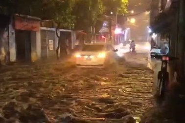 Ô tô tạo sóng khi tháo chạy qua đoạn đường ngập