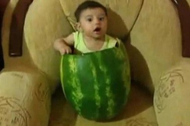 Em bé ngồi lọt thỏm trong vỏ quả dưa hấu