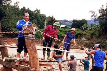 Bộ đội, dân quân giúp dân làm cầu treo cho học sinh đến trường
