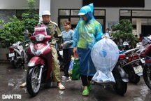 Người dân đội mưa đến ủng hộ các nạn nhân trong vụ cháy chung cư mini