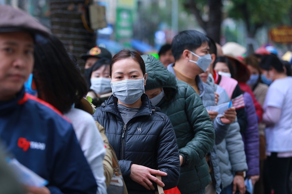 Hàng trăm người dân đội mưa xếp hàng nhận khẩu trang miễn phí - 1