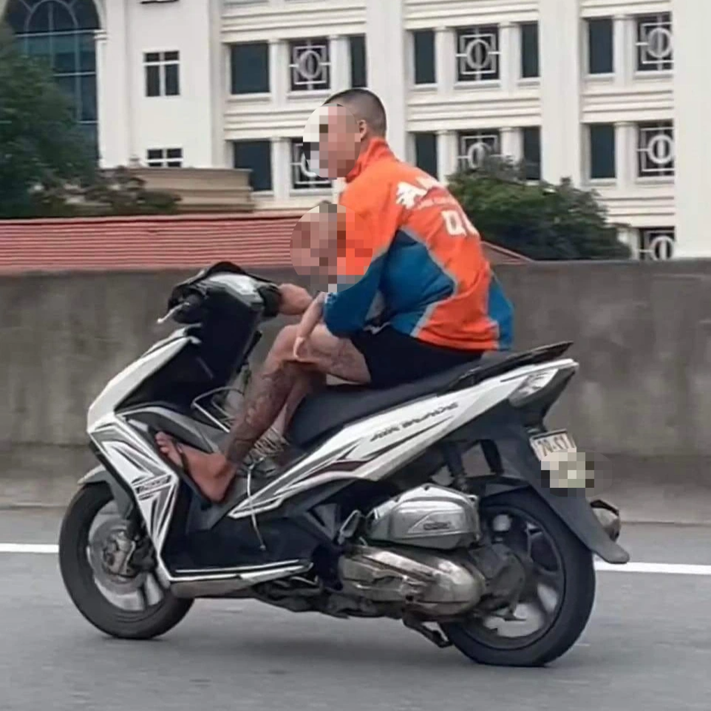 Thanh niên ôm bé trai phóng xe máy trên đường Vành đai 3 - 1 Thanh niên ôm bé trai phóng xe máy trên đường Vành đai 3 - 1